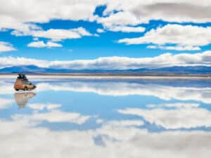 Expansive view of the Salar de Uyuni salt flats in Bolivia, showcasing the vast, white landscape under a clear blue sky